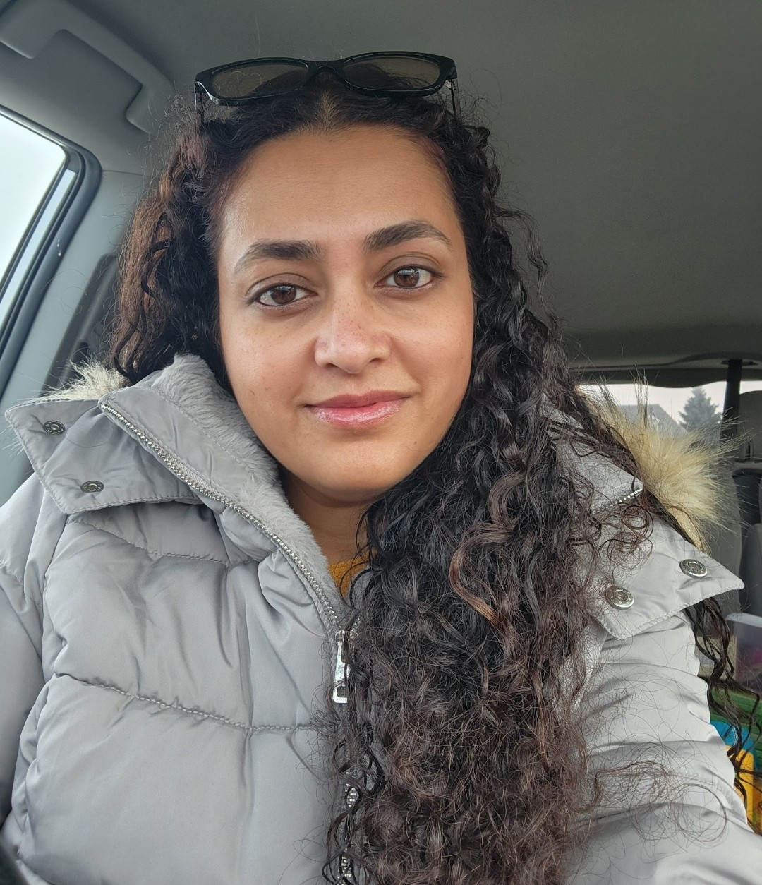 Portrait of Bariah Khan seated in a car wearing a winter coat.